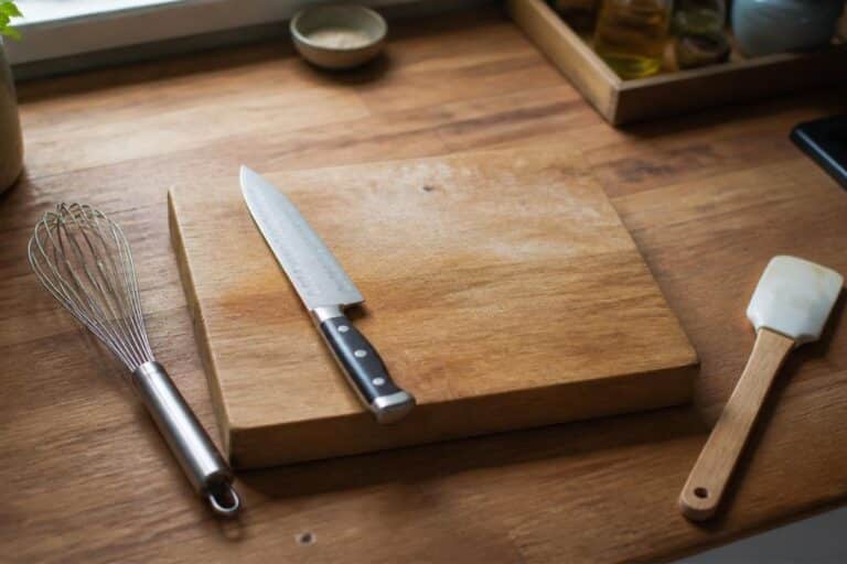 Ustensiles de cuisine essentiels disposés sur un plan de travail en bois